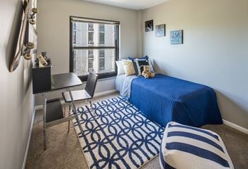 Bedroom photo with large window and blue furnishings